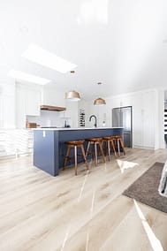 Contemporary kitchen featuring a blue island with seating, pendant lights, and skylights by Bowline Construction kitchen renovation contractor in Langley, BC