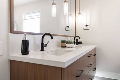 Bathroom featuring a double vanity with a large mirror and pendant lighting by Bowline Construction design-build contractors in Langley, BC