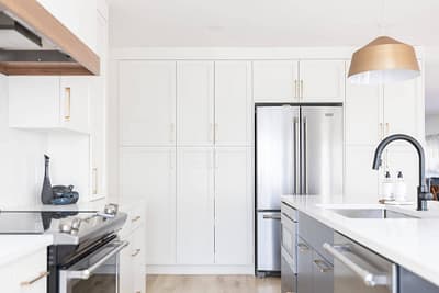 Bright white kitchen with shaker cabinets, gold hardware, and stainless steel appliances installed by Bowline Construction kitchen renovation contractor in Langley, BC