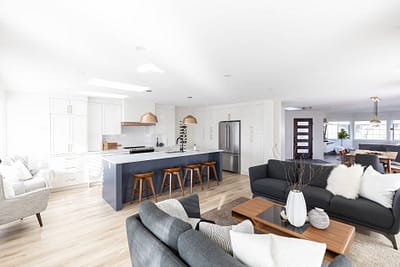 Contemporary living room with a kitchen island and dining area in the background installed by Bowline Construction home renovation contractors in Langley