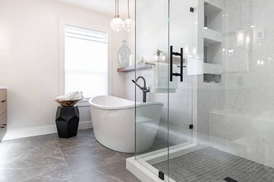 bathroom featuring a freestanding tub, a glass shower, and pendant lights by custom home builder langley, BC