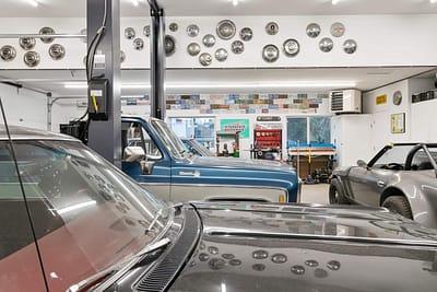 A large, well-lit outbuilding garage with a collection of classic cars by Bowline Construction in Langley, BC