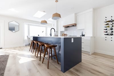 Contemporary kitchen featuring a blue island with seating, pendant lights, and skylights by Bowline Construction kitchen renovation contractor in Langley, BC