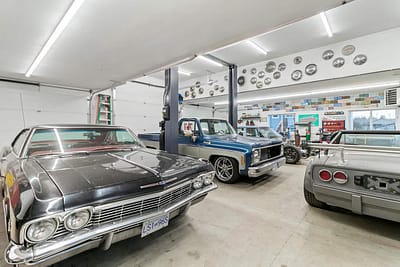 A large, well-lit outbuilding garage with a collection of classic cars by Bowline Construction in Langley, BC