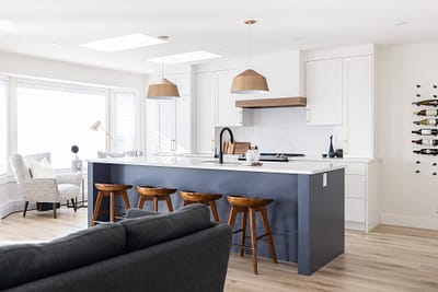 Contemporary kitchen featuring a blue island with seating, pendant lights, and skylights by Bowline Construction kitchen renovation contractor in Langley, BC