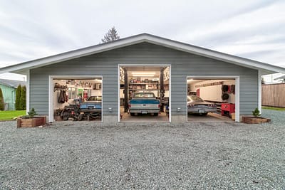 A large, detached garage outbuildings with two car bays and a gravel driveway by Bowline Construction in Langley, BC