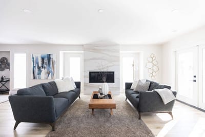 Contemporary living room with two gray sofas facing each other, a fireplace, and artwork by Bowline Construction design-build contractors in Langley, BC