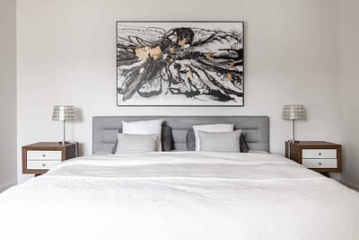 Bedroom with a gray upholstered bed, a large floral painting, in Langley, BC