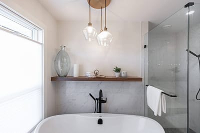 bathroom featuring a freestanding tub, a glass shower, and pendant lights by custom home builder langley, BC