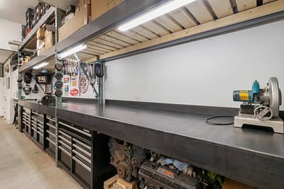 A well-organized workshop with a large workbench, tool cabinets, and shelves stocked with supplies in Langley, BC