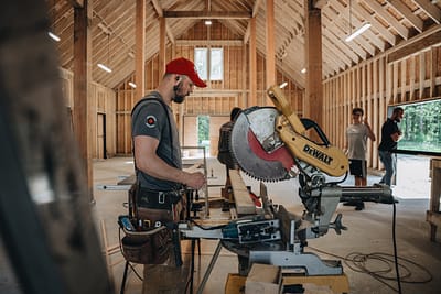 A pole barn construction is in progress. Bowline construction staff is using a construction equipment in langley