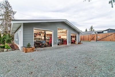 A large, detached garage outbuildings with two car bays and a gravel driveway by Bowline Construction in Langley, BC