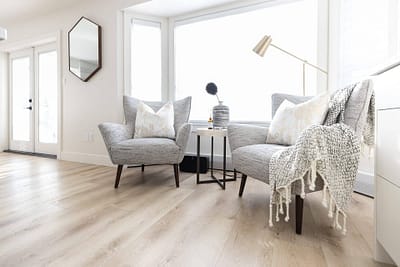 Contemporary living room featuring two armchairs, a side table, and a large window with natural light by Bowline Construction design-build contractors in Langley, BC