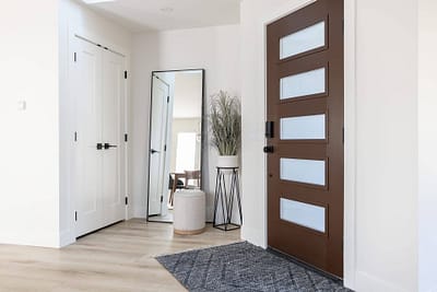 Entryway with a mirror and a brown door by Bowline Construction design-build contractors in Langley, BC