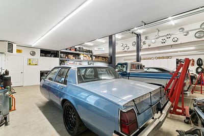 A large, well-lit outbuilding garage with a collection of classic cars by Bowline Construction in Langley, BC