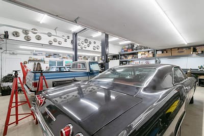 A large, well-lit outbuilding garage with a collection of classic cars by Bowline Construction in Langley, BC