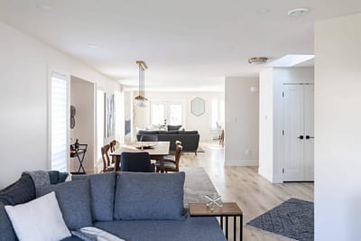 Home interior featuring a living room with a comfortable sofa, a dining area with a modern chandelier by Bowline Construction home renovation contractors in Langley, BC