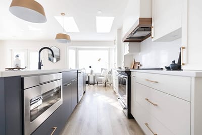 Bright white kitchen with shaker cabinets, gold hardware, and stainless steel appliances installed by Bowline Construction kitchen renovation contractor in Langley, BC