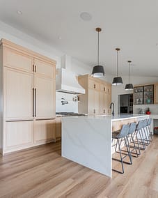 A bright, modern kitchen featuring light-colored wood cabinets.