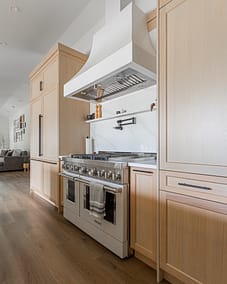 A kitchen with a large range oven and a custom hood installed by kitchen renovation contractors in Langley, BC