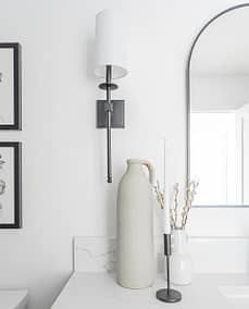 A picture of a bathroom wall with a lamp and a countertop with a vase with custom additions in Langley, BC