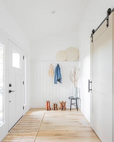 The entrance of a newly built home adorned with a striking white accent door, showcasing the expertise of home renovation contractors in Langley, BC