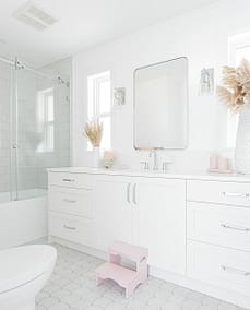 A picture of a bathroom with white countertop and a bathtub made by custom home builder Langley in Langley, BC