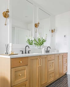 A bathroom with two faucets and a white marble sink made by home renovation contractors in Langley, BC