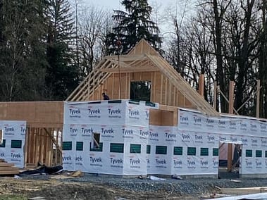 A pole barn under construction with the roof framed and covered in Tyvek house wrap by Bowline Construction in Langley, BC