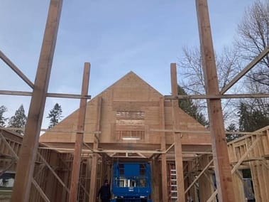 A framed pole barn under construction with a triangular roof and a large open space in the center by Bowline Construction in Langley, BC