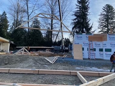 A pole barn under construction with the roof framed and covered in Tyvek house wrap by Bowline Construction in Langley, BC