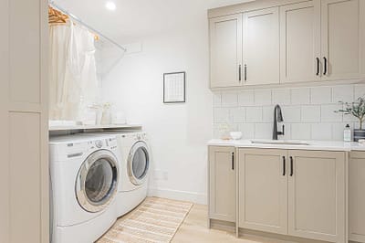 A picture of a laundry area with washing machines, cabinet made by a custom home builder langley in Langley, BC