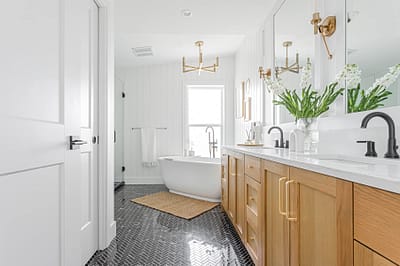 A bathroom with two faucets and a white marble sink and a bathtub made by home renovation contractors in Langley, BC