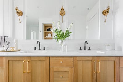 A bathroom with two faucets and a white marble sink made by home renovation contractors in Langley, BC