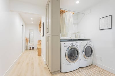 A picture of a laundry area with washing machines, cabinet made by a custom home builder langley in Langley, BC