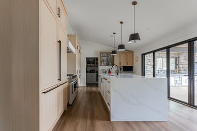 A bright, modern kitchen featuring light-colored wood cabinets.
