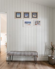 A custom addition hallway with a bench and framed art in Langley, BC