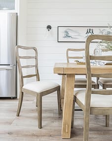 A white accent dining area with wooden tables and floors by renovation company in Langley, BC