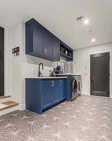 A well-lit laundry room with a gray geometric patterned tile floor.