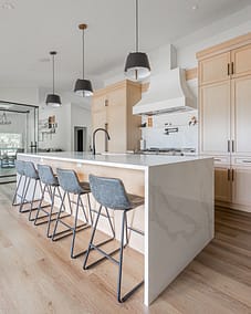 A modern kitchen with a large island and bar stools in Langley, BC