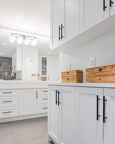 White kitchen cabinets with "Top Knobs Hopewell" pulls.