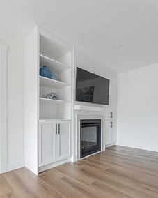 Built-in cabinets flanking a fireplace with a mounted TV, suitable for custom additions in Langley.