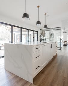 A modern kitchen with a large island and quartz countertop