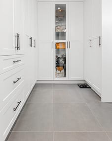 Modern white kitchen cabinetry with black hardware, commonly used by home renovation contractors in Langley
