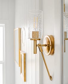 An image of a wall with brass colored lamps and picture frames with custom additions in Langley, BC