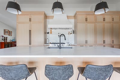 A bright, modern kitchen featuring light-colored wood cabinets.