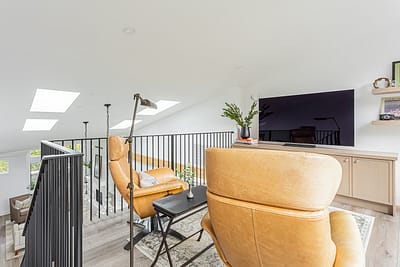 A second floor entertainment area with custom addition couch and TV