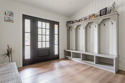 A bathroom with a double vanity, a large framed mirror, and pendant lights.