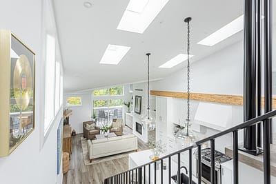 A white accent living room and kitchen with modern industrial kitchen equipment by kitchen renovation contractor in Langley, BC