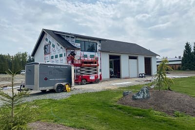 A white pole barn with a black roof, a testament to expert pole barn construction in Langley, BC